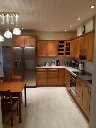 a kitchen with wooden cabinets and stainless steel appliances at Sun in Närpiö