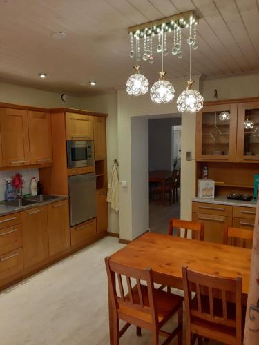 a kitchen with a wooden table and a dining room at Sun in Närpiö