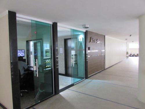 an empty hallway with glass doors in a building at Kitnet em Santos a melhor cidade do litoral paulista. in Santos