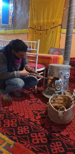 a woman sitting on the floor next to a table at Luna del fuego in Ifri