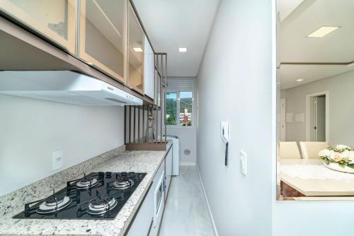 a kitchen with a stove and a counter top at Lindo Apartamento com 2 suítes e piscina em Bombas 705 in Bombas