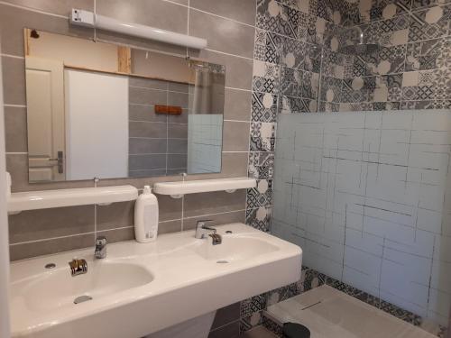 een badkamer met een wastafel en een spiegel bij A kwaba AD in Brens