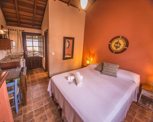 a bedroom with a large white bed in a room at Pousada Capitão Cook in Praia do Rosa