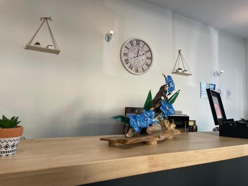 a counter with a clock on the wall and a table with a clock at Logis Hôtel Castel de Mirambel in Lourdes