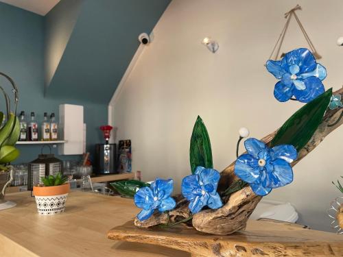 a vase with blue flowers on top of a table at Logis Hôtel Castel de Mirambel in Lourdes