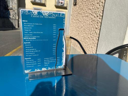 a blue table with a bottle on top of it at Logis Hôtel Castel de Mirambel in Lourdes