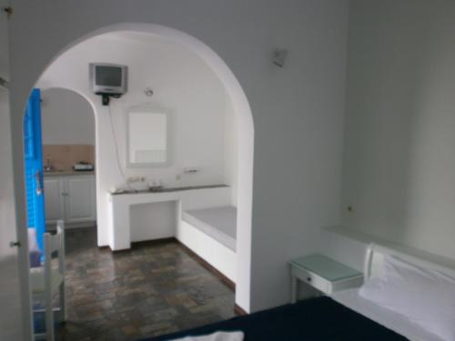 a white room with a bed and a sink at Aegean Village in Parikia