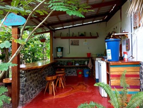 a kitchen with a counter and stools in a room at La Urraca Loca Hostel in Balgue