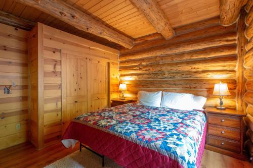 a bedroom with a bed in a log cabin at The Log Cabin home in Stevenson