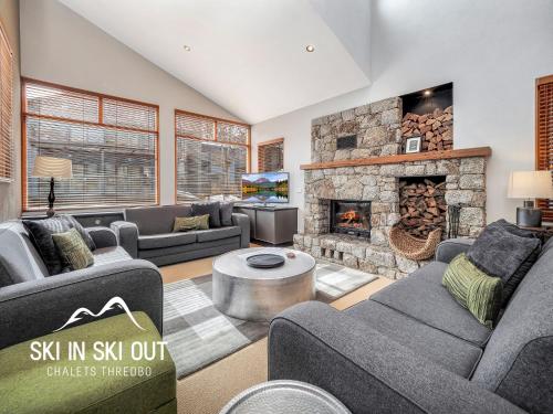 a living room with couches and a fireplace at Ski In Ski Out 16 in Thredbo