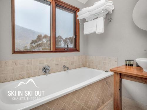 a bathroom with a bath tub and a sink at Ski In Ski Out 16 in Thredbo