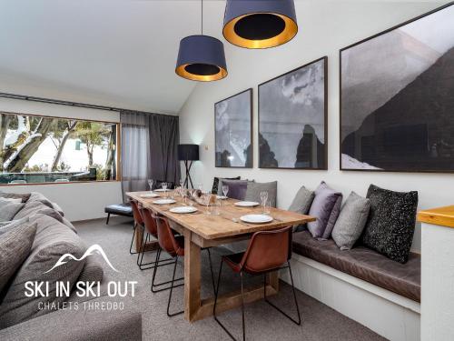 a dining room with a table and a couch at Ski In Ski Out #08 in Thredbo