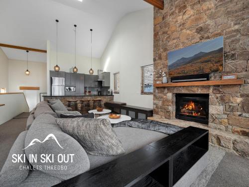a living room with a couch and a fireplace at Ski In Ski Out #08 in Thredbo