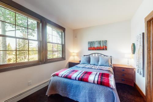 1 dormitorio con 1 cama y 2 ventanas en Bluebird Skies, en Granby
