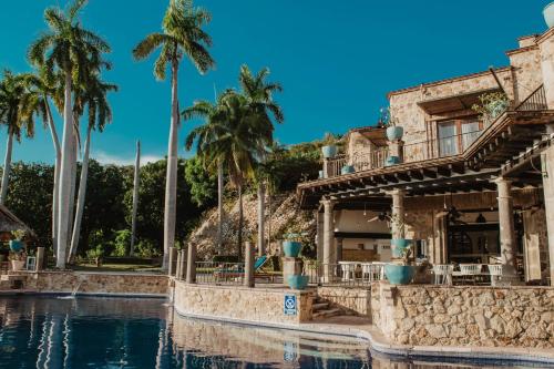 um resort com palmeiras e uma piscina em Casa Lisa em Acapulco