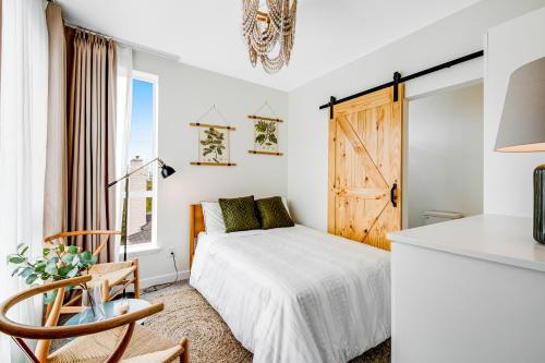 a white bedroom with a bed and a window at Capitol Hill Rooftop R & R in Seattle