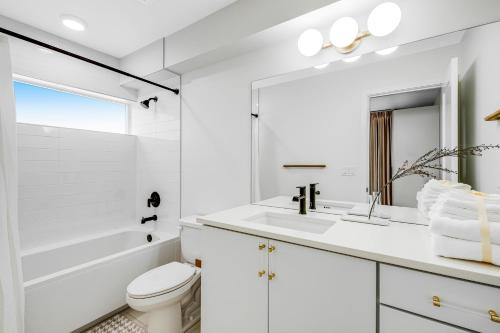 a white bathroom with a sink and a toilet at Capitol Hill Rooftop R & R in Seattle