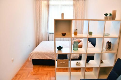 a room with a bed and a book shelf at Apartman Roses in Lukavica