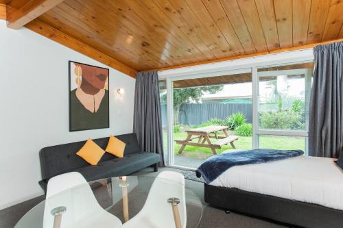 a bedroom with a bed and a glass table at Waikanae Beach Motel in Gisborne