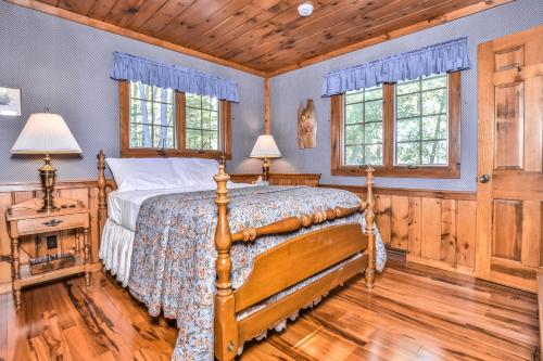 ein Schlafzimmer mit einem Bett und zwei Fenstern in der Unterkunft The Retreat in Presque Isle