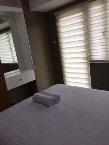 a white bed with a towel on top of it at Wind and Sea at Wind Residences in Tagaytay