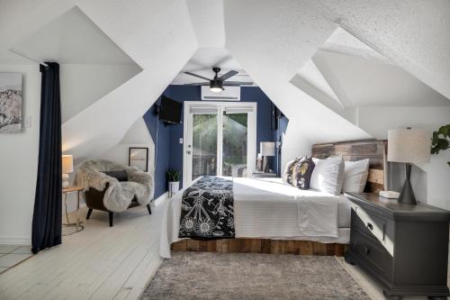 a bedroom with blue walls and a bed and a chair at Red Rock Inn Cottages in Springdale