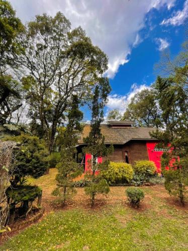 a house with red paint on the side of it at Chalé Cores da Mata in Brumadinho