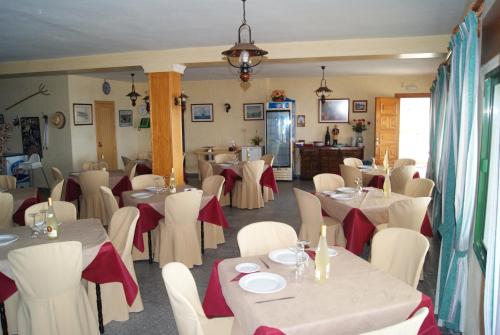 a dining room with white tables and white chairs at Apartamentos La Dorada in La Cala de Mijas
