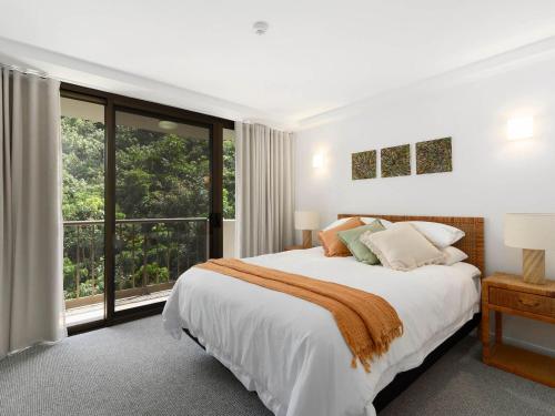 a white bedroom with a bed and a large window at The Rocks Resort Unit 8G in Gold Coast