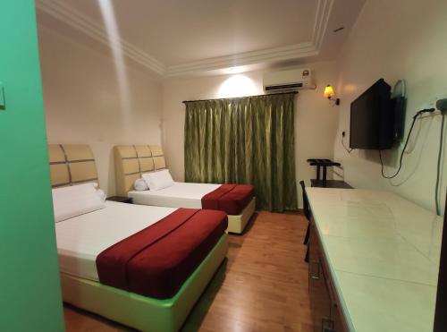 Habitación de hotel con 2 camas y TV de pantalla plana. en DARUL SALAM INN HOTEL en Kertih