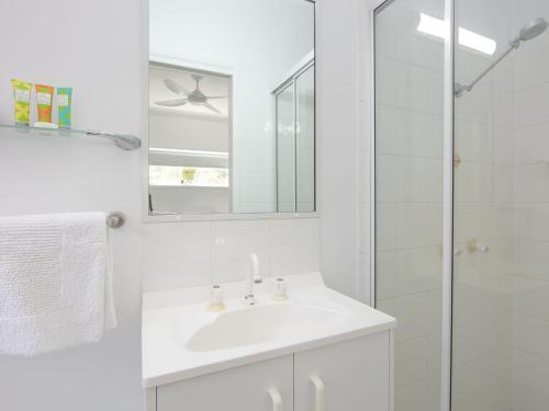 a white bathroom with a sink and a shower at Avalon 3 in Yamba