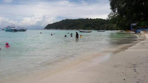 a group of people in the water at the beach at Samudra Beach Chalet in Perhentian Island