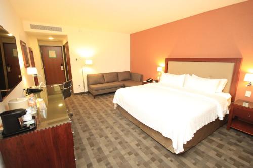 Кровать или кровати в номере Holiday Inn & Suites Plaza Mayor by IHG