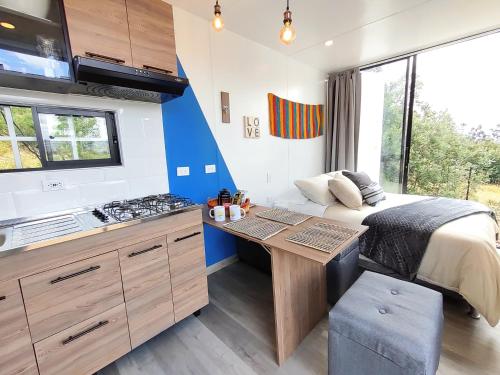 1 dormitorio con 1 cama y cocina con fogones en Libre Camp Azul, en Nemocón
