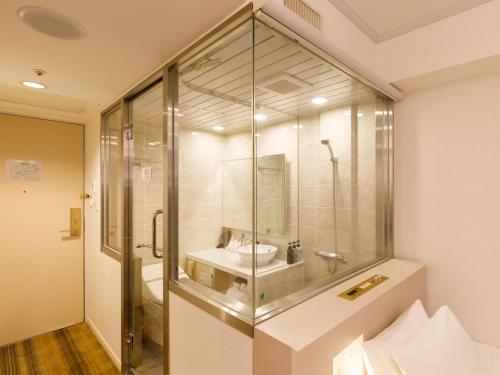 a bathroom with a glass shower and a sink at Chisun Grand Takayama in Takayama