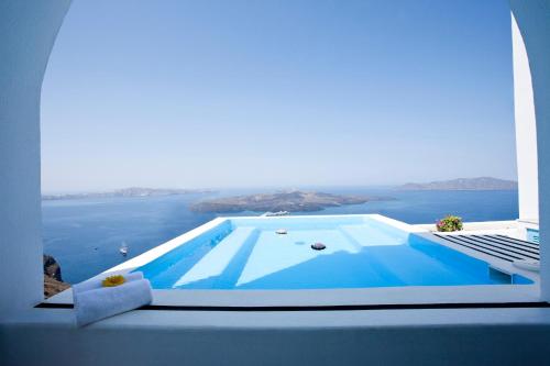 a swimming pool with a view of the water at Kastro Suites in Fira