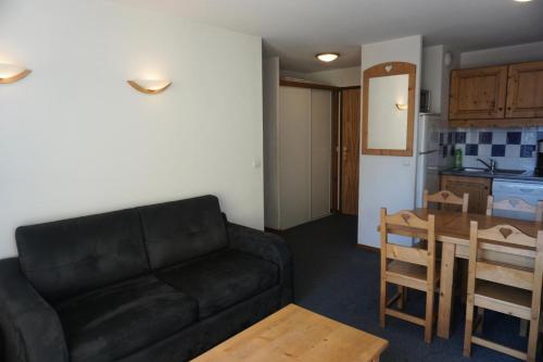 un salon avec un canapé noir et une cuisine dans l'établissement Résidence Balcons Du Soleil - 2 Pièces cabine 6 personnes MAE-2774, à Orcières