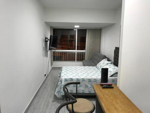麥德林的住宿－Aparta estudio amoblado Medellin, San joaquin，小房间,配有一张床和一张桌子