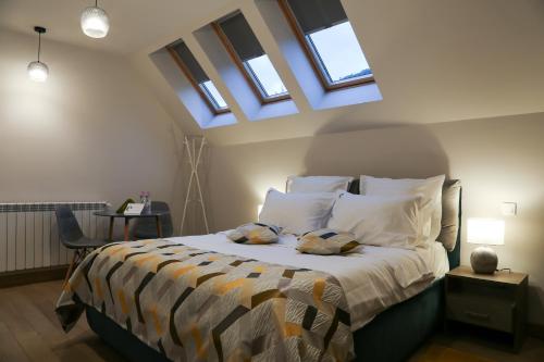 a bedroom with a bed with two pillows and windows at Expecto Apartments in Sinaia