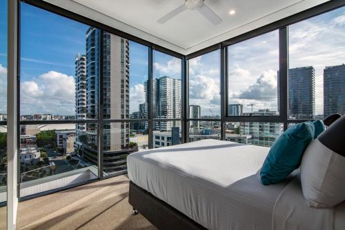 a bedroom with a bed and large windows at Hope Street Apartments by CLLIX in Brisbane
