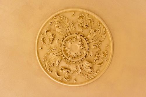 a gold clock is on a wall at Hôtel LÉONOR the place to live in Strasbourg