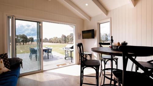 a living room with a porch with a table and chairs at Wallinga Farmstay Mudgee in Mudgee