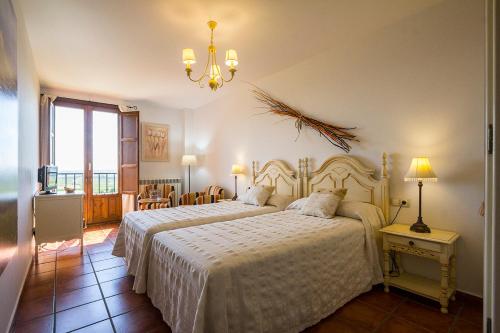 una camera con due letti e un lampadario a braccio di Mar de viñas a San Asensio