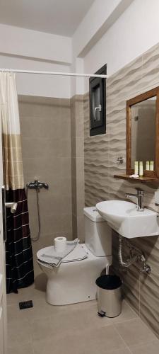 a bathroom with a toilet and a sink at Amoraninew in Batsi