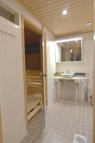 a bathroom with a sink and a shower and a toilet at Tunturipöllö 2 in Ruka