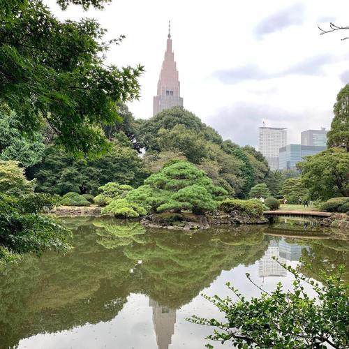 a pond in a park with a city in the background at Hotel Koryukaku in Tokyo