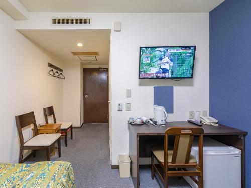 a hospital room with a desk and a tv on the wall at Hotel Koryukaku in Tokyo