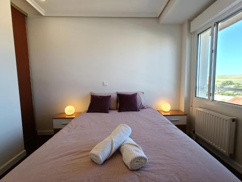 Un dormitorio con una cama con una toalla. en Bonito duplex cerca de la playa y de Santander, en Santa Cruz de Bezana