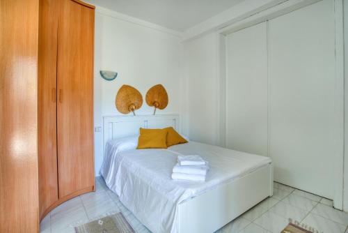ein Schlafzimmer mit einem weißen Bett und gelben Kissen in der Unterkunft Old Side Platja d Aro in Platja  d'Aro