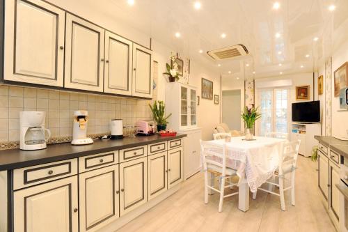 uma cozinha com armários brancos e uma mesa e cadeiras brancas em Pavillon Clara Flor em Prades